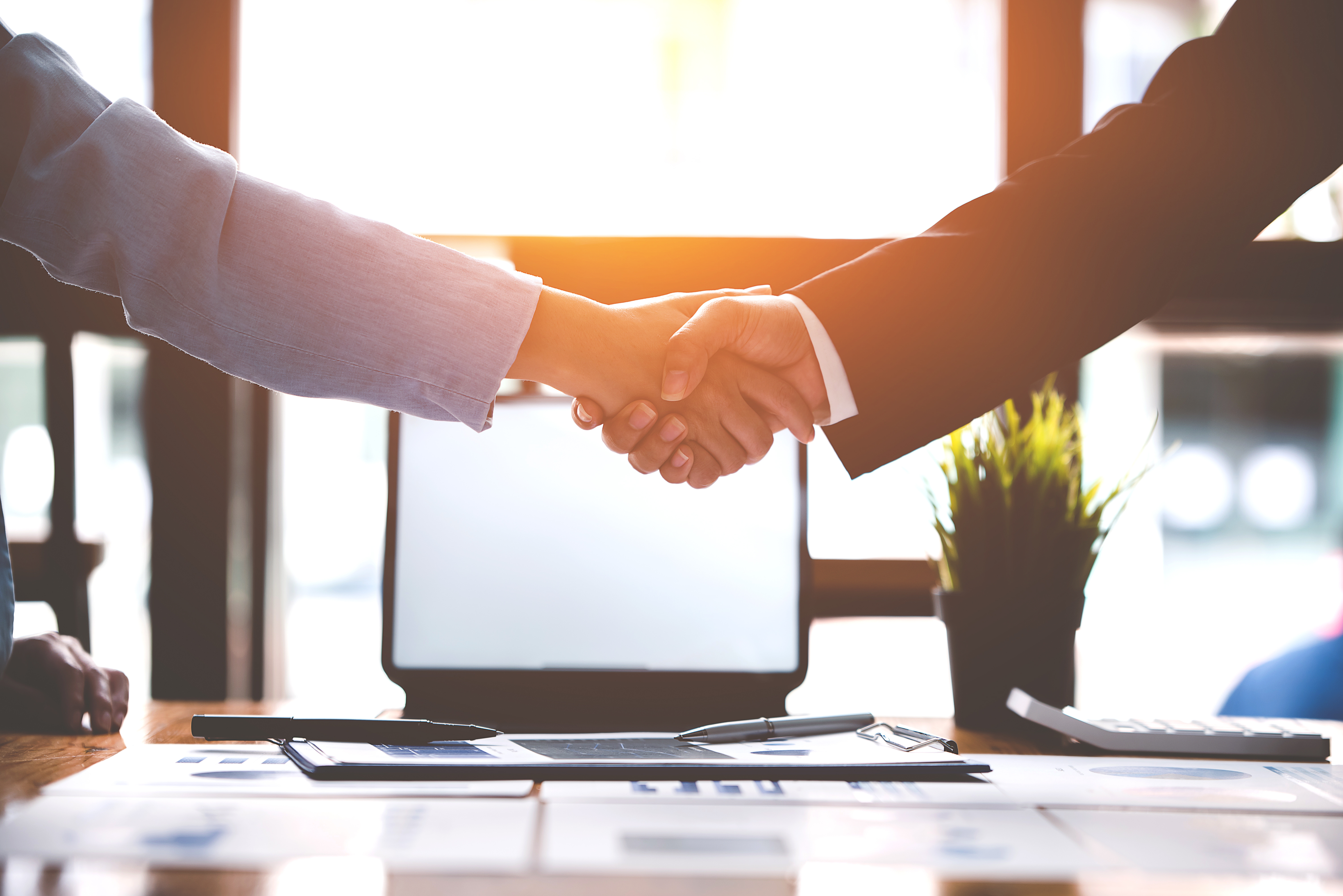 Shaking hands over desk